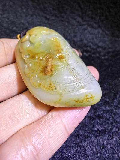 收藏级新疆喀什河籽料，府上有龙手把件男款，原籽洒金皮，可见天然毛孔撞击坑等。原皮原色，俏色巧雕寓意吉祥安康，尺寸：5.8cm*3.9cm**2.1cm
克重：75.2g自带国检证书！