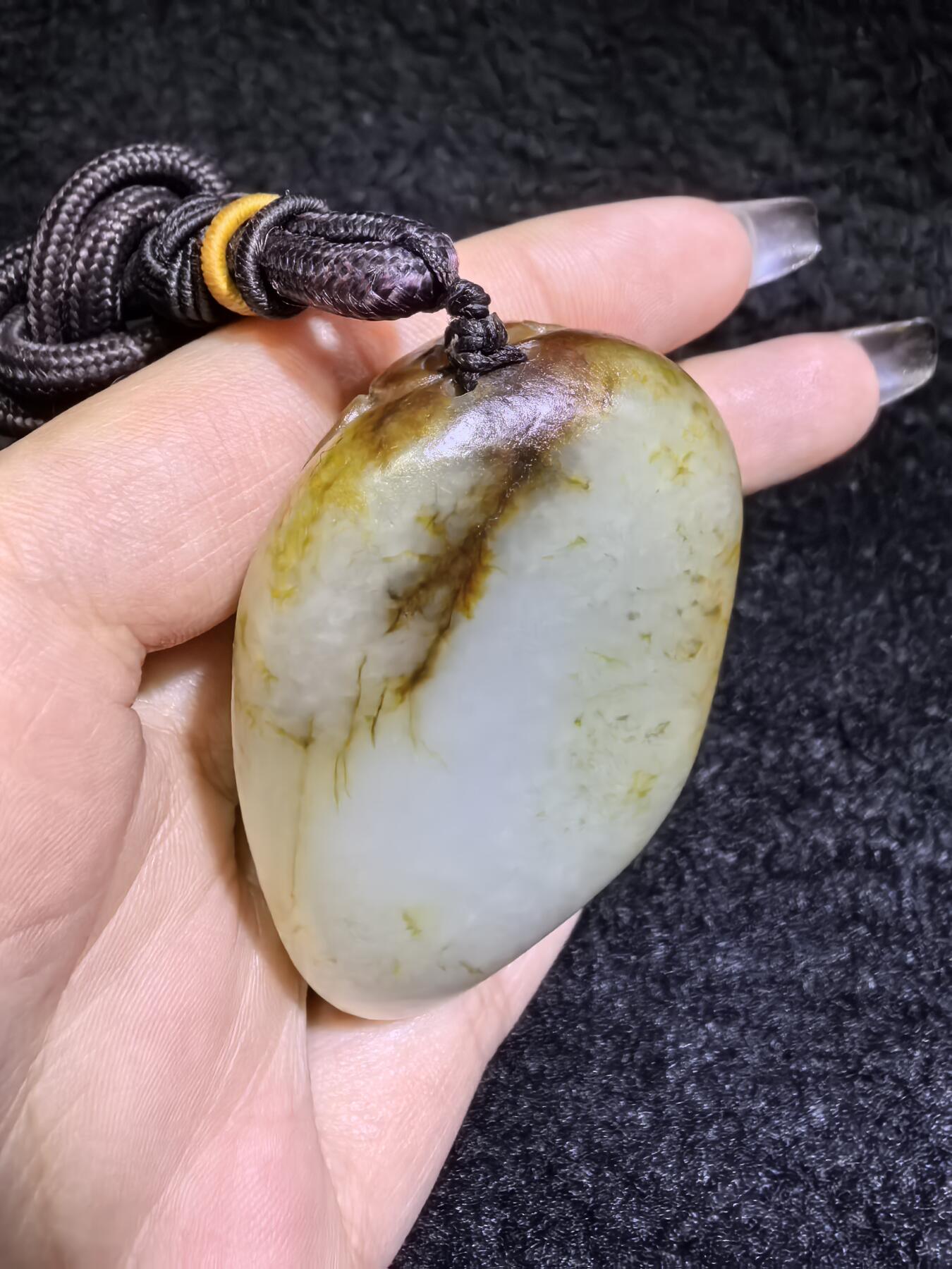 收藏级新疆喀什河籽料，府上有龙手把件男款，原籽洒金皮，可见天然毛孔撞击坑等。原皮原色，俏色巧雕寓意吉祥安康，尺寸：5.8cm*3.9cm**2.1cm
克重：75.2g自带国检证书！