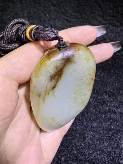 收藏级新疆喀什河籽料，府上有龙手把件男款，原籽洒金皮，可见天然毛孔撞击坑等。原皮原色，俏色巧雕寓意吉祥安康，尺寸：5.8cm*3.9cm**2.1cm
克重：75.2g自带国检证书！