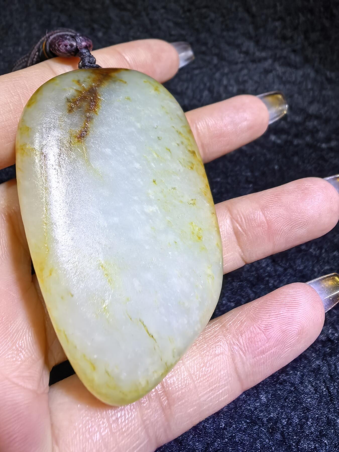 收藏级新疆喀什河籽料，府上有龙手把件男款，原籽洒金皮，可见天然毛孔撞击坑等。原皮原色，俏色巧雕寓意吉祥安康，尺寸：5.8cm*3.9cm**2.1cm
克重：75.2g自带国检证书！