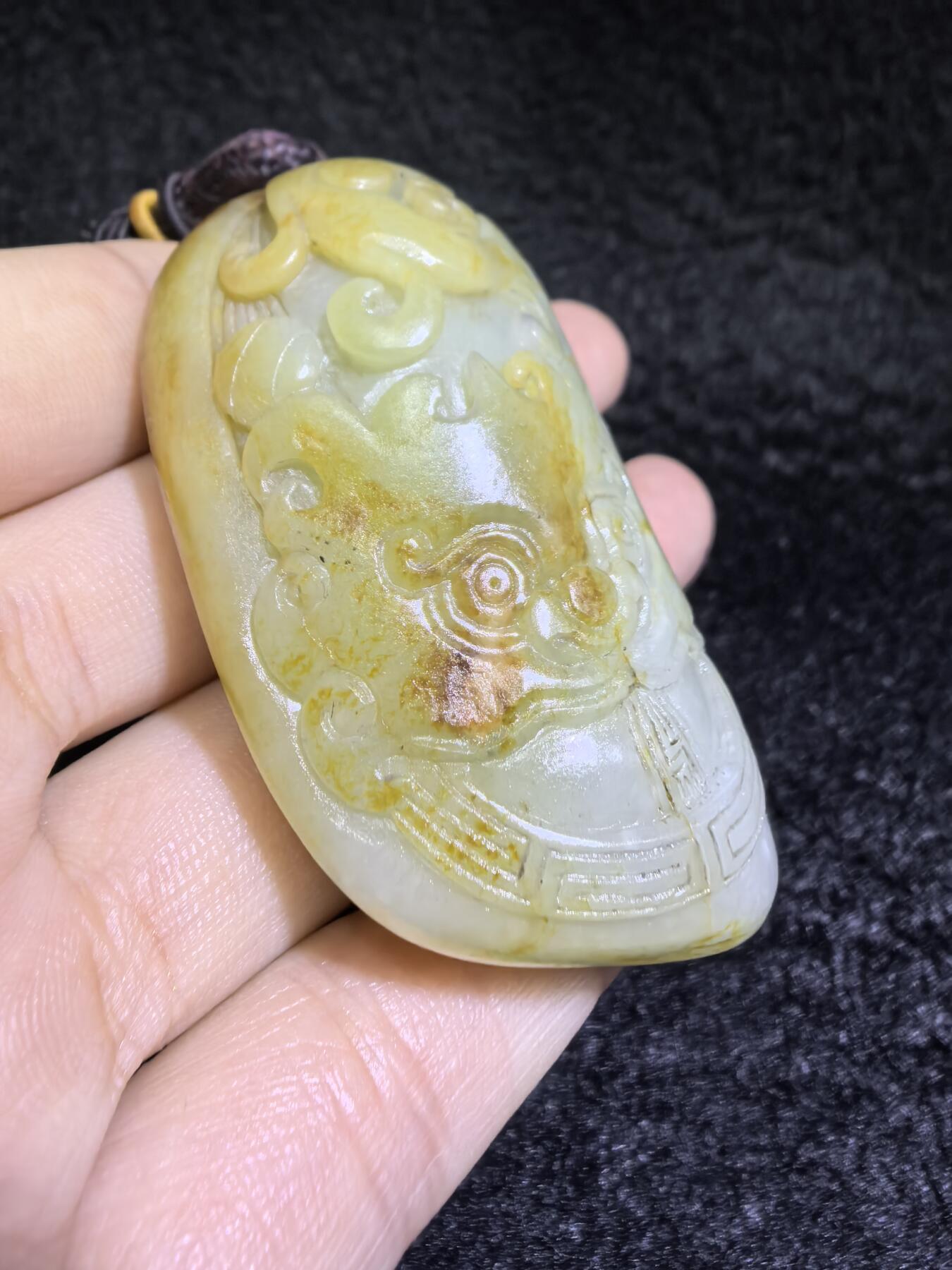 收藏级新疆喀什河籽料，府上有龙手把件男款，原籽洒金皮，可见天然毛孔撞击坑等。原皮原色，俏色巧雕寓意吉祥安康，尺寸：5.8cm*3.9cm**2.1cm
克重：75.2g自带国检证书！