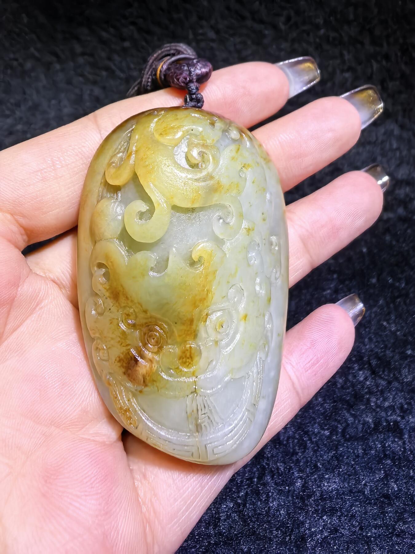 收藏级新疆喀什河籽料，府上有龙手把件男款，原籽洒金皮，可见天然毛孔撞击坑等。原皮原色，俏色巧雕寓意吉祥安康，尺寸：5.8cm*3.9cm**2.1cm
克重：75.2g自带国检证书！