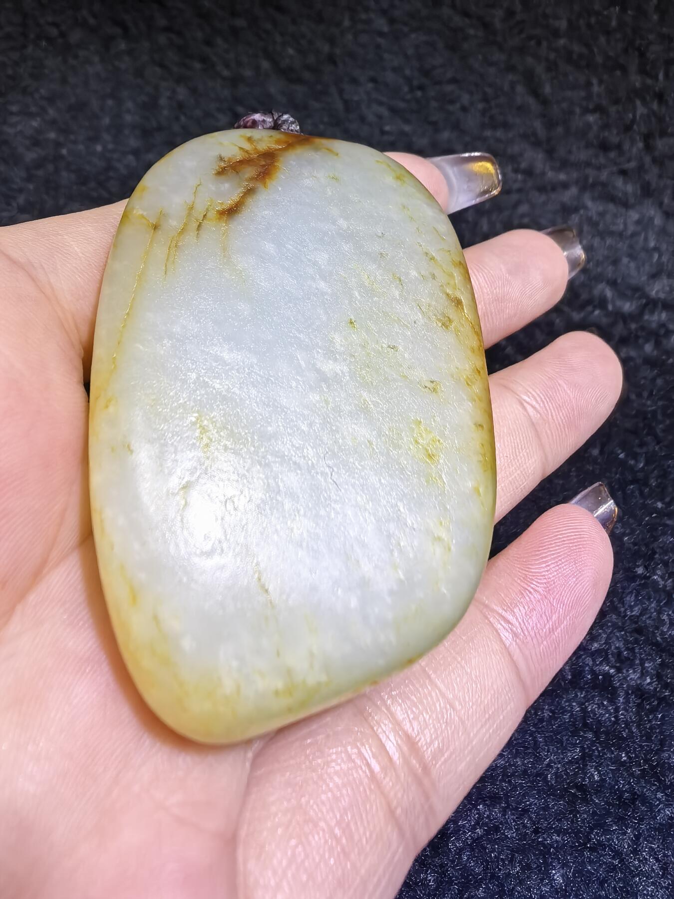 收藏级新疆喀什河籽料，府上有龙手把件男款，原籽洒金皮，可见天然毛孔撞击坑等。原皮原色，俏色巧雕寓意吉祥安康，尺寸：5.8cm*3.9cm**2.1cm
克重：75.2g自带国检证书！