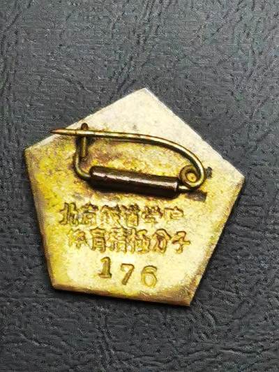 - 正面：五角星造型，珐琅工艺打造，白色底面上有金色跑步运动员浮雕，顶部缀红色五角星，下方刻有“1955”年份，整体设计融合了体育主题与时代符号。
​
- 背面：刻有“北京铁路管理局 体育积极分子”字样及编号“176”，明确了颁发单位、表彰类别与藏品的唯一性。
​
​
- 1950年代是新中国体育事业奠基期，铁路系统作为大型国企，积极开展职工体育活动，这类纪念章是对参与体育建设、推动全民健身职工的表彰。
​
- 北京铁道学院（今北京交通大学）作为铁路系统核心高校，同步推行体育育人理念，这类徽章也成为校园体育文化的重要载体。