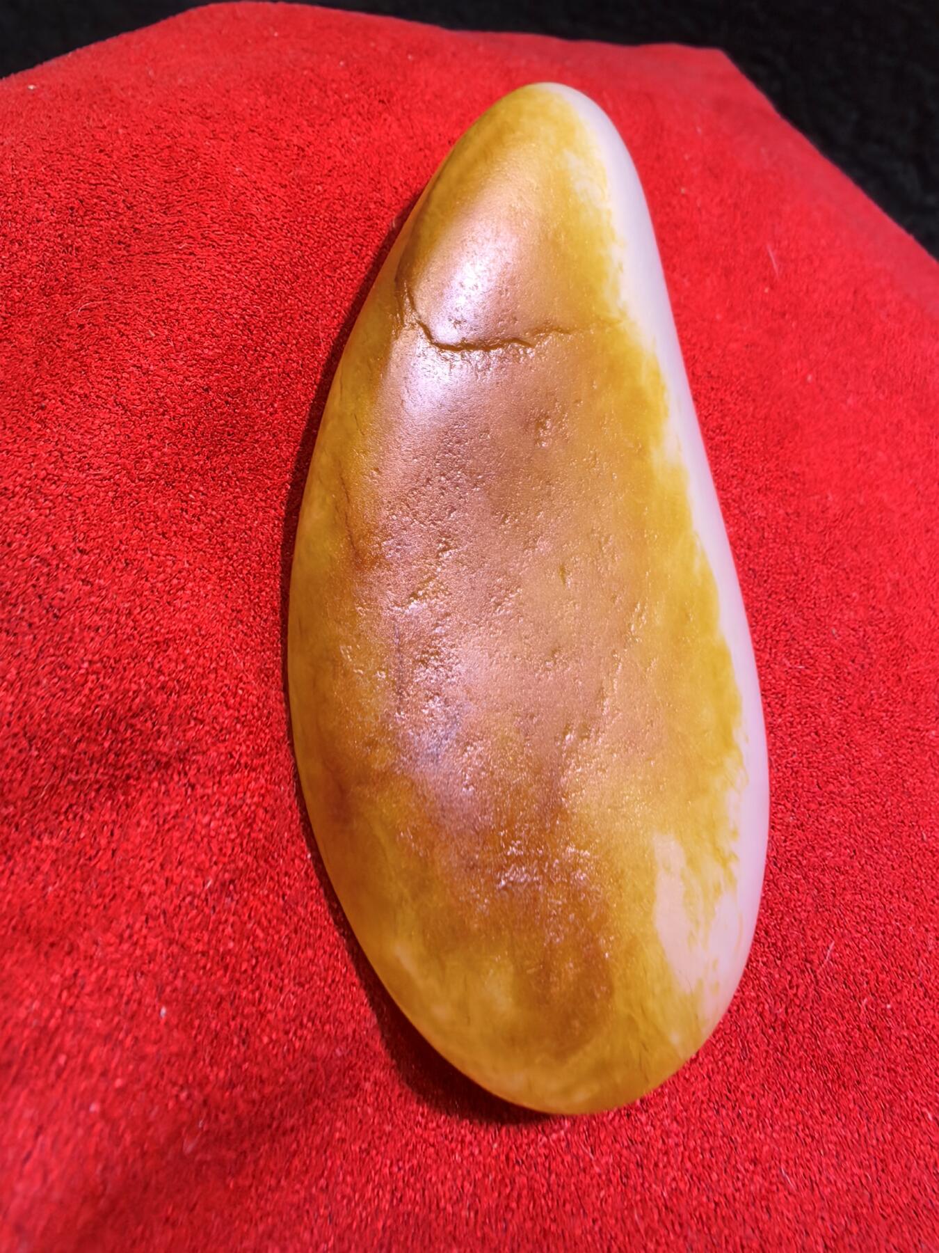 收藏级新疆和田籽料金红皮吊坠挂件手把件男款，原皮、原籽、无修、无烧皮、无做色、通体可见天然毛孔撞击坑等。玉质温润细腻，过灯无明显结构。细度高老熟，暖白不闪青，皮色鲜艳，亮气自然。未打孔。实物实拍，所见即所得。
尺寸:7.5cm*3.9cm*1.3cm
克重:68.5g