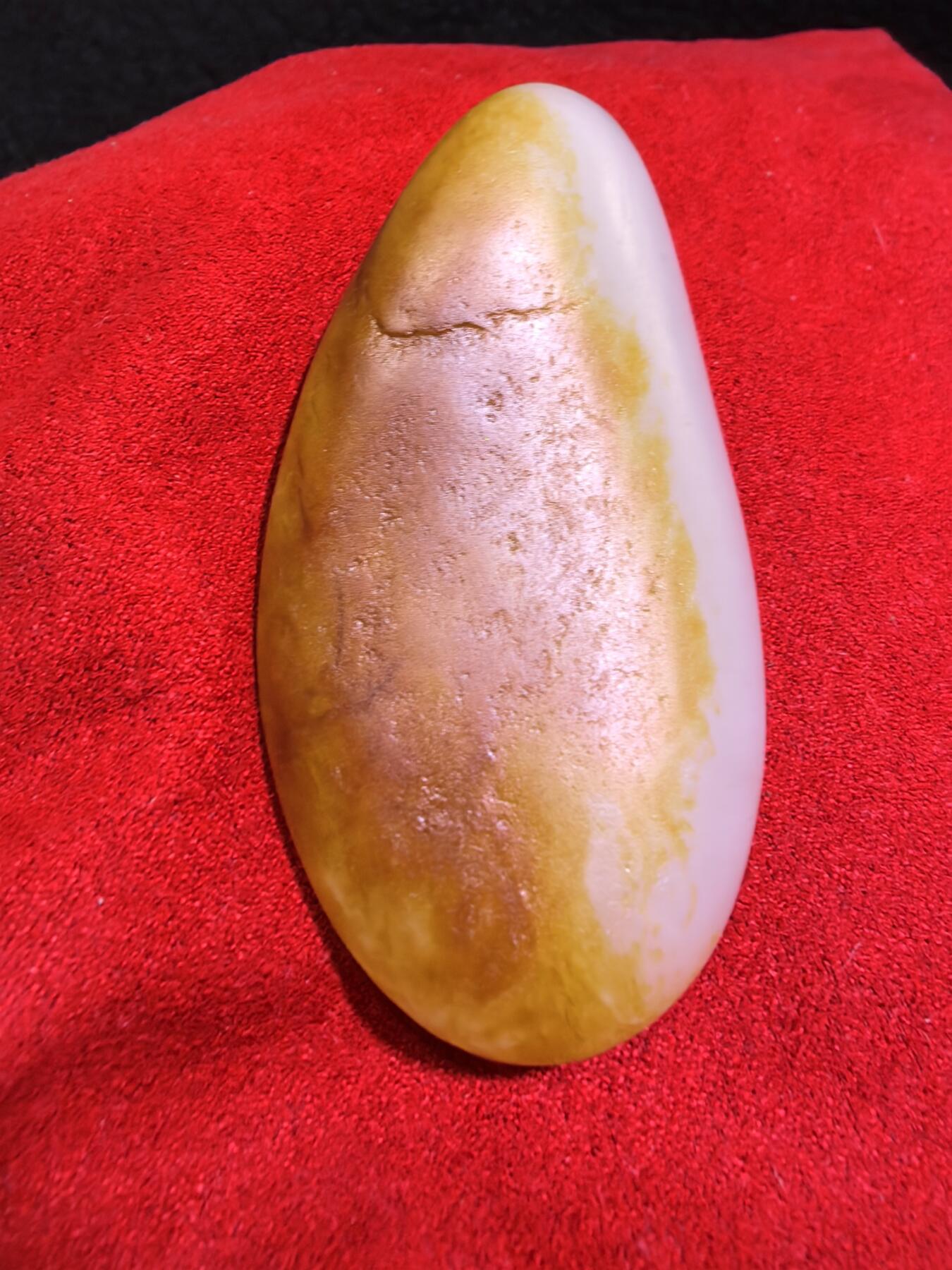 收藏级新疆和田籽料金红皮吊坠挂件手把件男款，原皮、原籽、无修、无烧皮、无做色、通体可见天然毛孔撞击坑等。玉质温润细腻，过灯无明显结构。细度高老熟，暖白不闪青，皮色鲜艳，亮气自然。未打孔。实物实拍，所见即所得。
尺寸:7.5cm*3.9cm*1.3cm
克重:68.5g