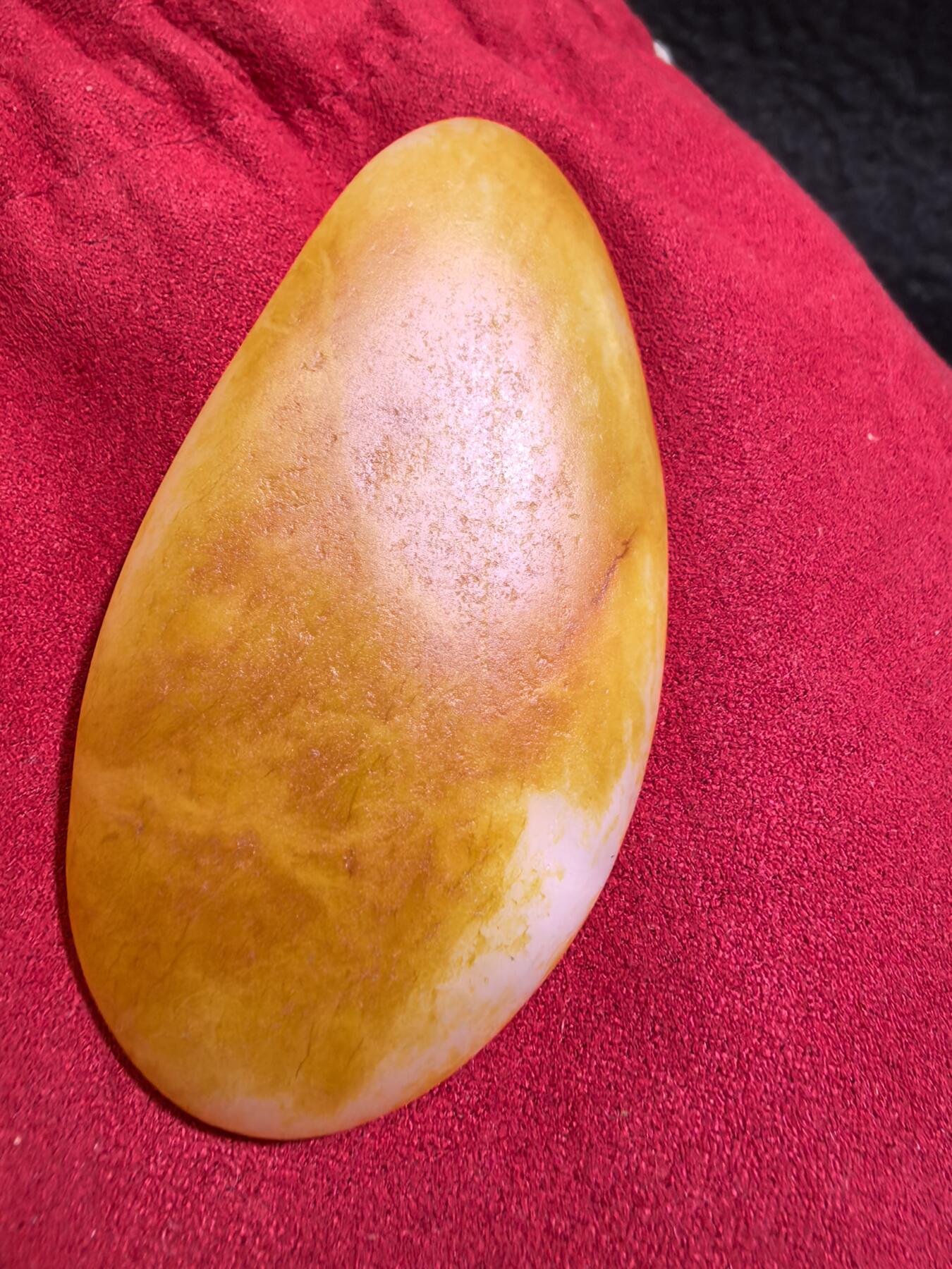 收藏级新疆和田籽料金红皮吊坠挂件手把件男款，原皮、原籽、无修、无烧皮、无做色、通体可见天然毛孔撞击坑等。玉质温润细腻，过灯无明显结构。细度高老熟，暖白不闪青，皮色鲜艳，亮气自然。未打孔。实物实拍，所见即所得。
尺寸:7.5cm*3.9cm*1.3cm
克重:68.5g