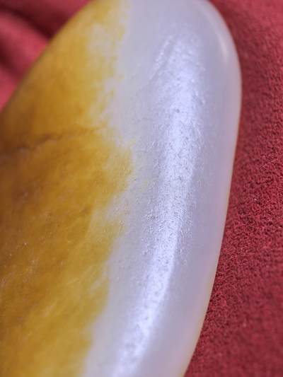 收藏级新疆和田籽料金红皮吊坠挂件手把件男款，原皮、原籽、无修、无烧皮、无做色、通体可见天然毛孔撞击坑等。玉质温润细腻，过灯无明显结构。细度高老熟，暖白不闪青，皮色鲜艳，亮气自然。未打孔。实物实拍，所见即所得。
尺寸:7.5cm*3.9cm*1.3cm
克重:68.5g