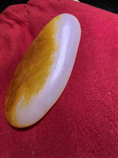 收藏级新疆和田籽料金红皮吊坠挂件手把件男款，原皮、原籽、无修、无烧皮、无做色、通体可见天然毛孔撞击坑等。玉质温润细腻，过灯无明显结构。细度高老熟，暖白不闪青，皮色鲜艳，亮气自然。未打孔。实物实拍，所见即所得。
尺寸:7.5cm*3.9cm*1.3cm
克重:68.5g