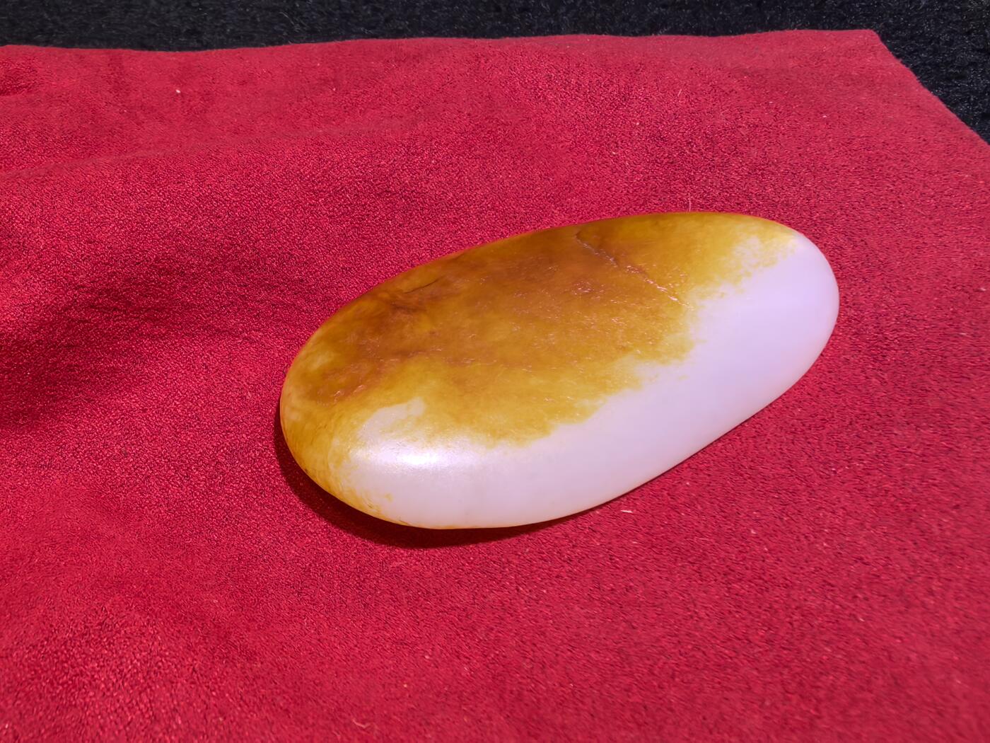 收藏级新疆和田籽料金红皮吊坠挂件手把件男款，原皮、原籽、无修、无烧皮、无做色、通体可见天然毛孔撞击坑等。玉质温润细腻，过灯无明显结构。细度高老熟，暖白不闪青，皮色鲜艳，亮气自然。未打孔。实物实拍，所见即所得。
尺寸:7.5cm*3.9cm*1.3cm
克重:68.5g