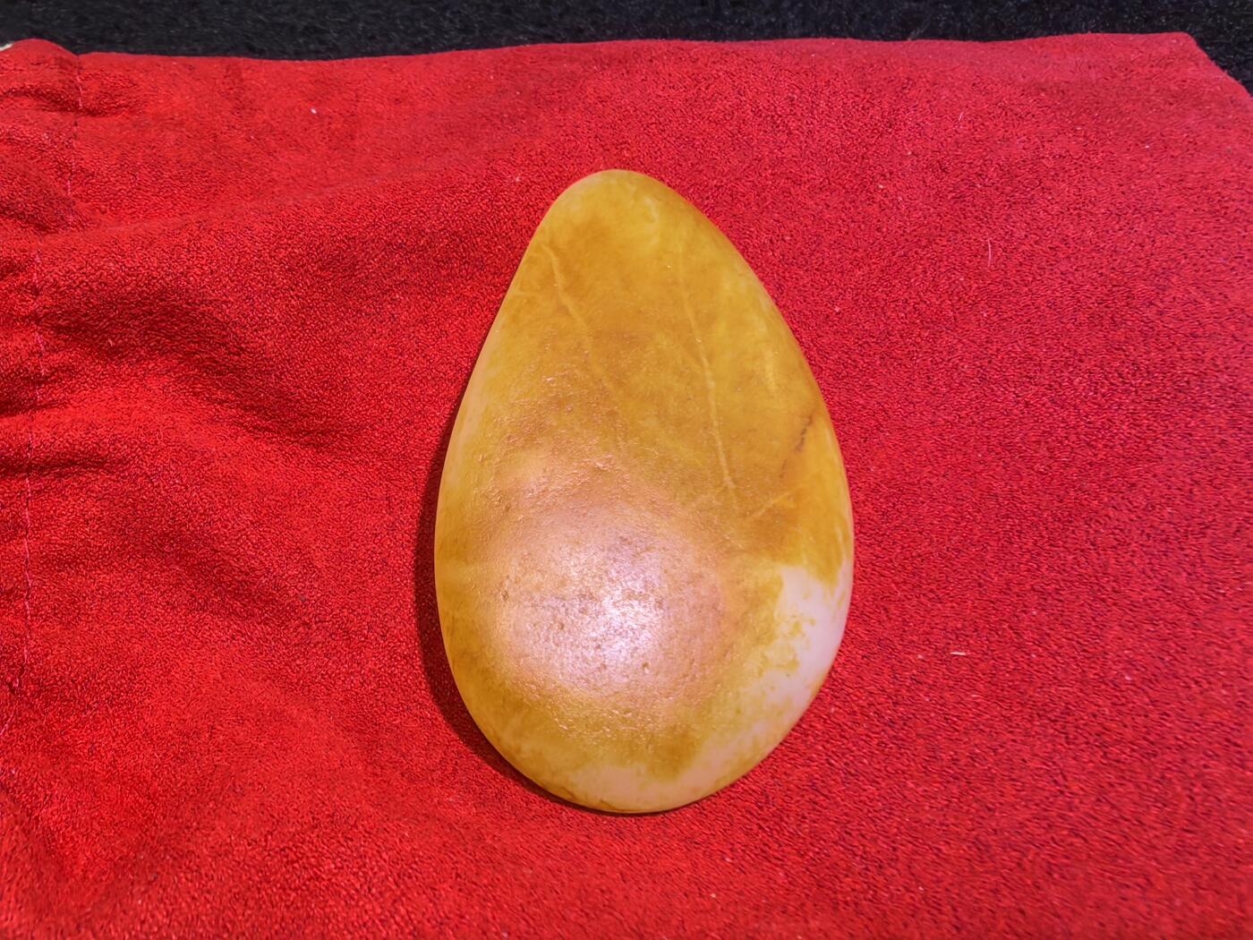 收藏级新疆和田籽料金红皮吊坠挂件手把件男款，原皮、原籽、无修、无烧皮、无做色、通体可见天然毛孔撞击坑等。玉质温润细腻，过灯无明显结构。细度高老熟，暖白不闪青，皮色鲜艳，亮气自然。未打孔。实物实拍，所见即所得。
尺寸:7.5cm*3.9cm*1.3cm
克重:68.5g