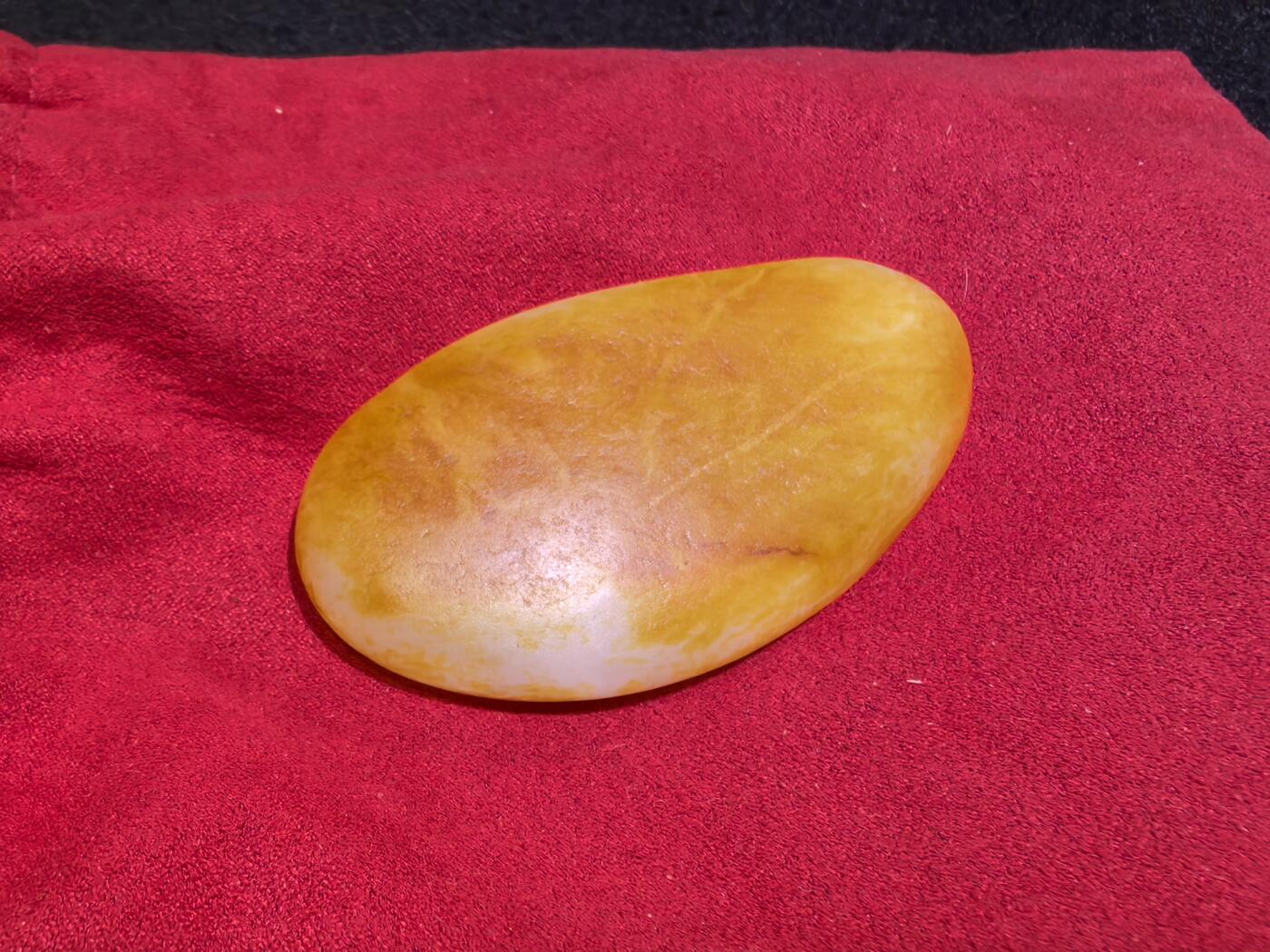 收藏级新疆和田籽料金红皮吊坠挂件手把件男款，原皮、原籽、无修、无烧皮、无做色、通体可见天然毛孔撞击坑等。玉质温润细腻，过灯无明显结构。细度高老熟，暖白不闪青，皮色鲜艳，亮气自然。未打孔。实物实拍，所见即所得。
尺寸:7.5cm*3.9cm*1.3cm
克重:68.5g