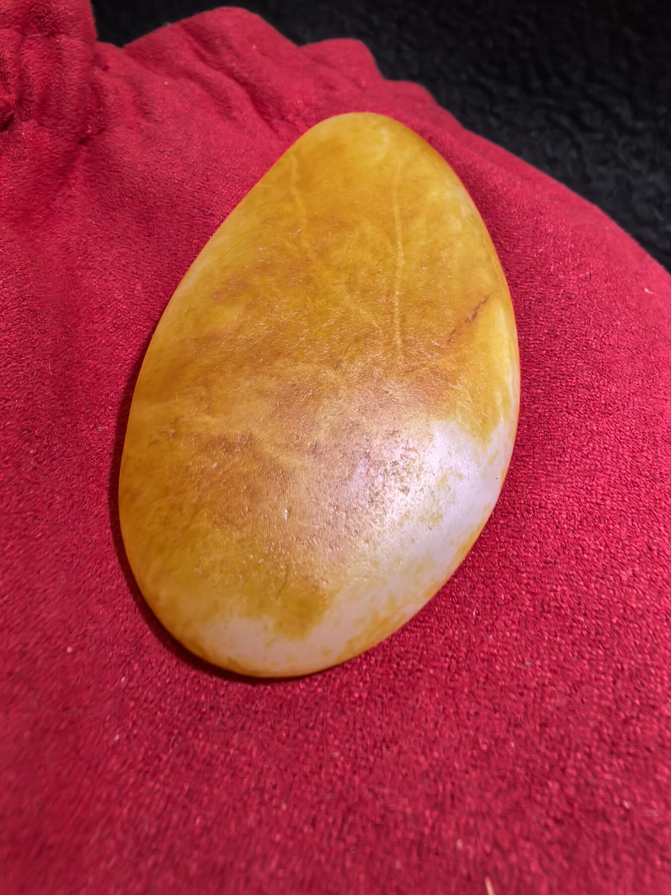 收藏级新疆和田籽料金红皮吊坠挂件手把件男款，原皮、原籽、无修、无烧皮、无做色、通体可见天然毛孔撞击坑等。玉质温润细腻，过灯无明显结构。细度高老熟，暖白不闪青，皮色鲜艳，亮气自然。未打孔。实物实拍，所见即所得。
尺寸:7.5cm*3.9cm*1.3cm
克重:68.5g