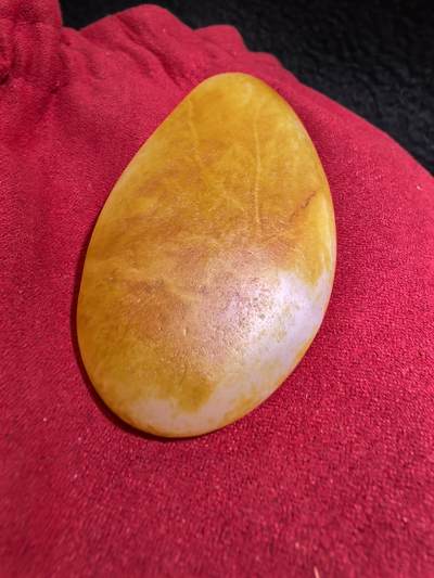 收藏级新疆和田籽料金红皮吊坠挂件手把件男款，原皮、原籽、无修、无烧皮、无做色、通体可见天然毛孔撞击坑等。玉质温润细腻，过灯无明显结构。细度高老熟，暖白不闪青，皮色鲜艳，亮气自然。未打孔。实物实拍，所见即所得。
尺寸:7.5cm*3.9cm*1.3cm
克重:68.5g