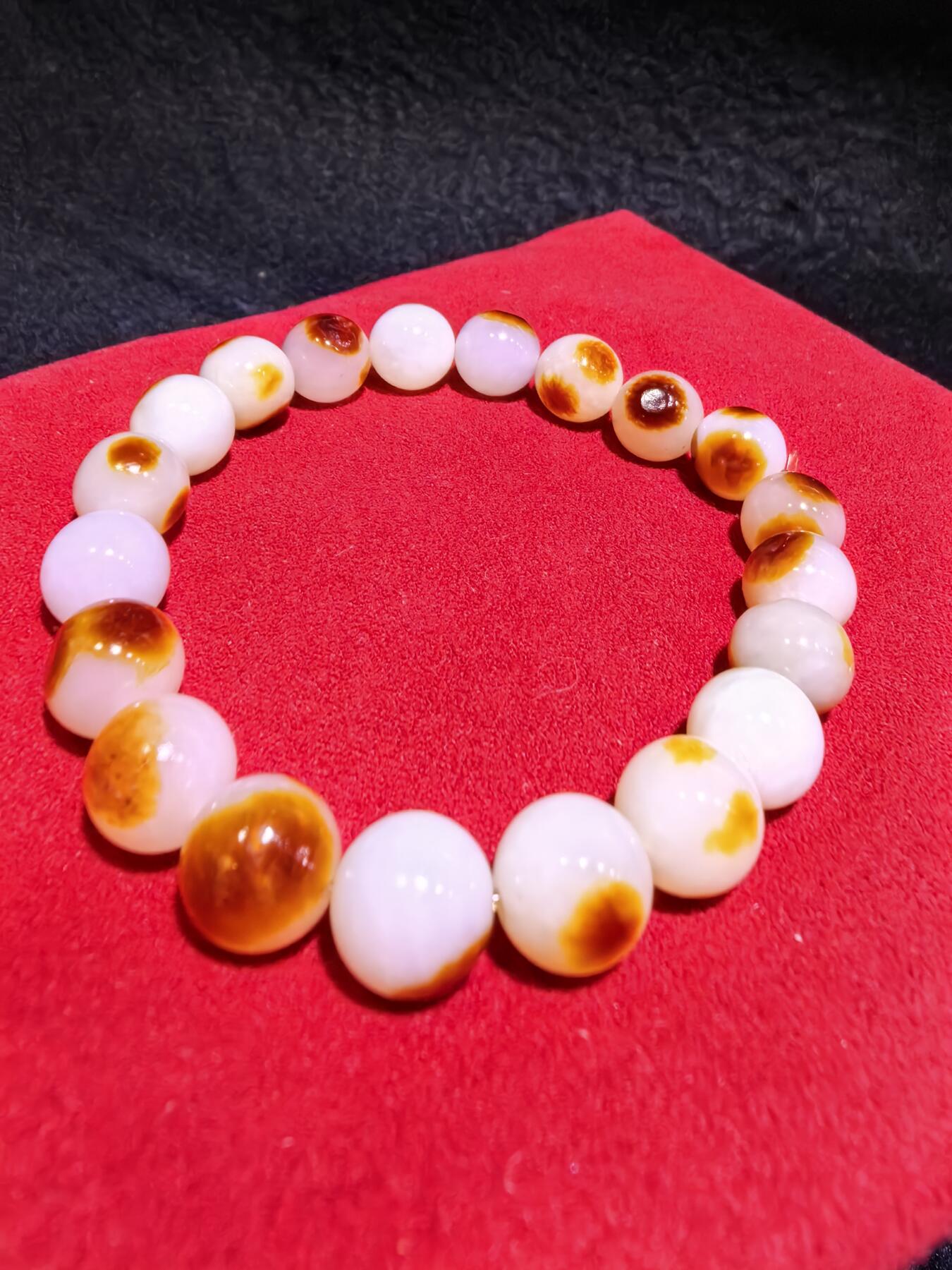 收藏级新疆和田籽料玛丽艳枣红皮手串佛珠男女款，原皮原色，高油高细，玛丽艳红皮的和田籽料，其皮色特点鲜明，常令人惊艳。这种被誉为老河道料的美玉，其色泽鲜艳饱满，宛如晚霞中的一抹红云，引人驻足欣赏。同时，其皮色与玉质紧密结合，相互映衬，更显独特魅力。个别珠微结构，不归圆，尺寸:1.0cm男女均可佩戴。克重:30g