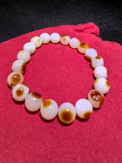 收藏级新疆和田籽料玛丽艳枣红皮手串佛珠男女款，原皮原色，高油高细，玛丽艳红皮的和田籽料，其皮色特点鲜明，常令人惊艳。这种被誉为老河道料的美玉，其色泽鲜艳饱满，宛如晚霞中的一抹红云，引人驻足欣赏。同时，其皮色与玉质紧密结合，相互映衬，更显独特魅力。个别珠微结构，不归圆，尺寸:1.0cm男女均可佩戴。克重:30g