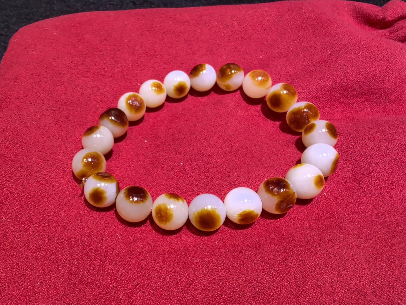 收藏级新疆和田籽料玛丽艳枣红皮手串佛珠男女款，原皮原色，高油高细，玛丽艳红皮的和田籽料，其皮色特点鲜明，常令人惊艳。这种被誉为老河道料的美玉，其色泽鲜艳饱满，宛如晚霞中的一抹红云，引人驻足欣赏。同时，其皮色与玉质紧密结合，相互映衬，更显独特魅力。个别珠微结构，不归圆，尺寸:1.0cm男女均可佩戴。克重:30g