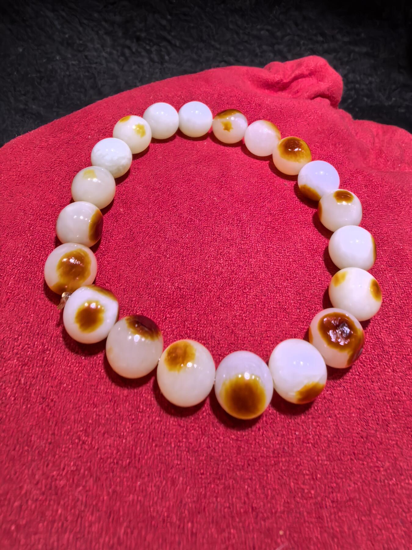 收藏级新疆和田籽料玛丽艳枣红皮手串佛珠男女款，原皮原色，高油高细，玛丽艳红皮的和田籽料，其皮色特点鲜明，常令人惊艳。这种被誉为老河道料的美玉，其色泽鲜艳饱满，宛如晚霞中的一抹红云，引人驻足欣赏。同时，其皮色与玉质紧密结合，相互映衬，更显独特魅力。个别珠微结构，不归圆，尺寸:1.0cm男女均可佩戴。克重:30g