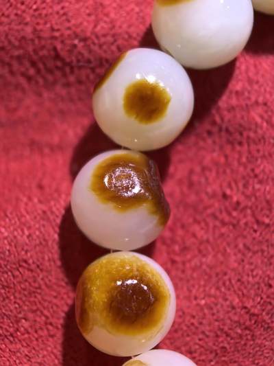 收藏级新疆和田籽料玛丽艳枣红皮手串佛珠男女款，原皮原色，高油高细，玛丽艳红皮的和田籽料，其皮色特点鲜明，常令人惊艳。这种被誉为老河道料的美玉，其色泽鲜艳饱满，宛如晚霞中的一抹红云，引人驻足欣赏。同时，其皮色与玉质紧密结合，相互映衬，更显独特魅力。个别珠微结构，不归圆，尺寸:1.0cm男女均可佩戴。克重:30g