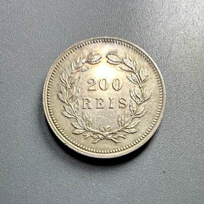 葡萄牙王国1891年200瑞斯的银币
	●	肖像与人物：
币面是卡洛斯一世（Carlos I）的侧面像（葡萄牙国王，1889 - 1908年在位），肖像风格体现19世纪末欧洲王室钱币的写实艺术特征。
	●	铭文与背景：
环绕葡萄牙文“CARLOS I REI DE PORTUGAL”（大意为“卡洛斯一世，葡萄牙国王”），明确君主身份与国家属性；下方“1891” 是铸造年份，“ALVES” 是雕刻师的名字（负责钱币肖像的模具雕刻）。
	●	材质与形制：圆形形制，边缘有珠纹装饰，工艺规整。