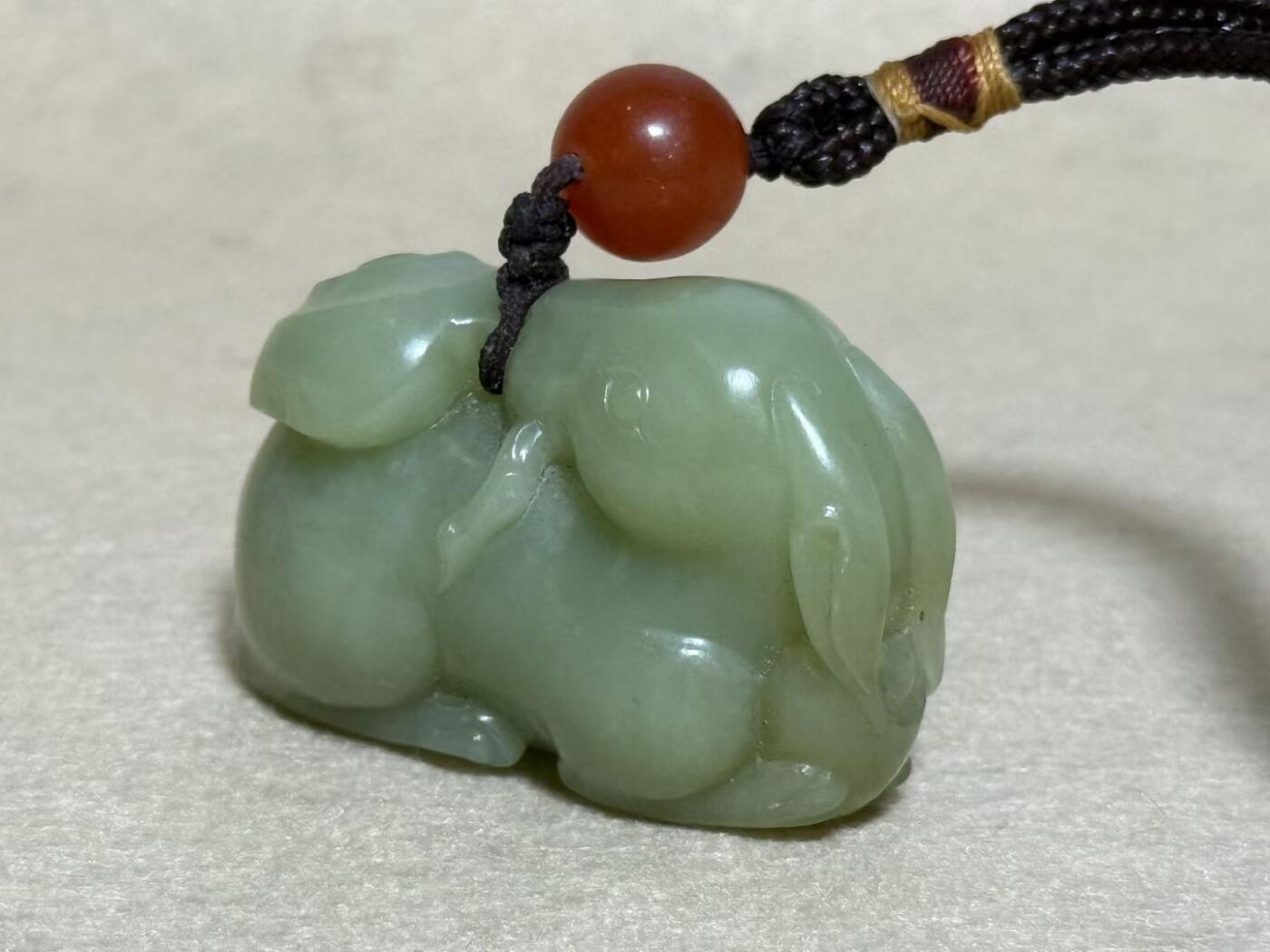 和田玉羊携灵芝手把件
玉质细腻，雕工生动，灵芝造型寓意吉祥
配红玛瑙珠，挂绳完整
成色几乎全新，无明显瑕疵
适合把玩收藏，送礼自用皆宜
无证书，重量约80克