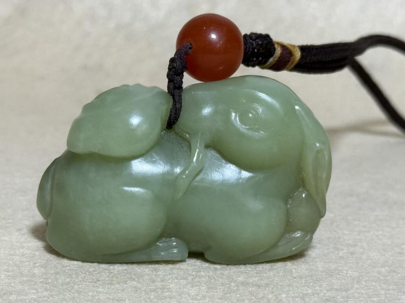 和田玉羊携灵芝手把件
玉质细腻，雕工生动，灵芝造型寓意吉祥
配红玛瑙珠，挂绳完整
成色几乎全新，无明显瑕疵
适合把玩收藏，送礼自用皆宜
无证书，重量约80克