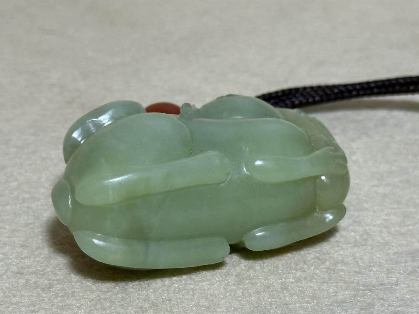 和田玉羊携灵芝手把件
玉质细腻，雕工生动，灵芝造型寓意吉祥
配红玛瑙珠，挂绳完整
成色几乎全新，无明显瑕疵
适合把玩收藏，送礼自用皆宜
无证书，重量约80克