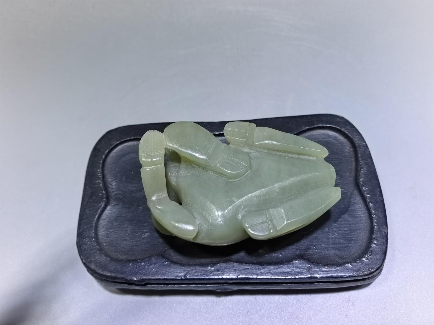 旧藏和田青白玉卧牛镇纸，传世雅物。
玉质青润细腻，包浆醇厚自然，雕工娴熟流畅，卧牛造型憨态可掬，栩栩如生。
牛角弯转，神态悠然，肌理线条精准传神，尽显古玉之韵与匠人之心。
既是文房镇纸，亦是案头雅赏，承载着“牛气冲天、扭转乾坤”的美好寓意，为藏家不可多得的臻品。5.5cm＊3.6cm＊2.0cm
克重：53.2g