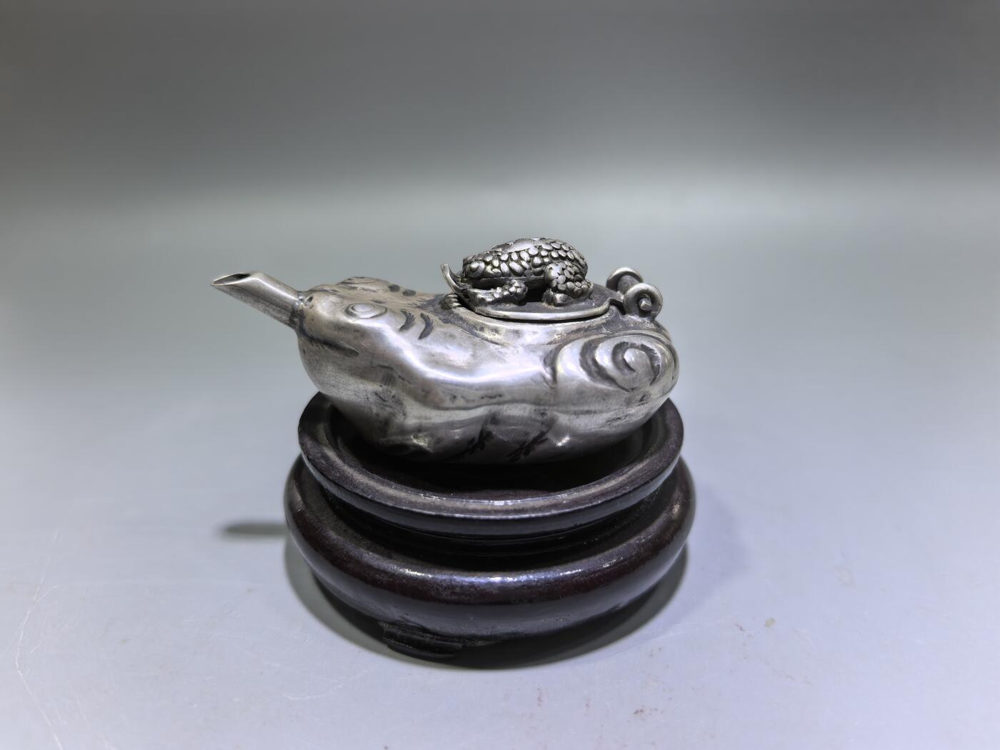 老银金蟾砚滴案头纳福墨韵生清代·老银金蟾纹砚滴材质：足银工艺：手工锻打、高浮雕錾刻器型：随形砚滴，云纹为底，金蟾为钮，壶嘴精巧品相：传世美品，包浆醇厚，工艺精湛金蟾为传统招财瑞兽，此砚滴以银为材，将瑞兽与文房雅器结合，既具实用价值，又含吉祥寓意，是清代银制文房的精品之作极具收藏与赏玩价值​6.3cm*4.0cm*2.8cm克重：24g#砚滴#清代#老银