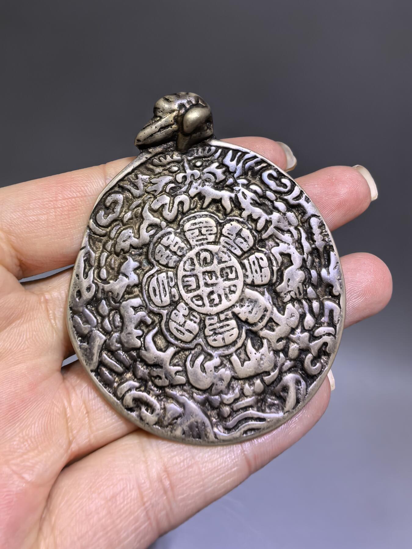 清代藏传九宫八卦牌｜藏地护佑，岁月凝华【清代·藏传九宫八卦护身牌】
材质：铜
工艺：手工铸造、满工高浮雕錾刻
纹饰：中央九宫八卦咒轮，环绕十二生肖、护法神兽、梵文真言
品相：传世美品，包浆醇厚，工艺精湛，保存完好
九宫八卦牌是藏传佛教中最具影响力的护身法器之一此牌为清代传世之物，工艺精湛，文化价值极高。6.6cm*5.48cm*0.3cm克重：52.1g
