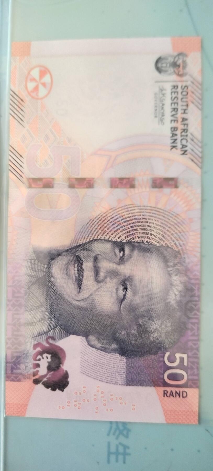 南非50兰特正面：曼德拉头像、头像两侧的微缩文字取自南非宪法序言、英文行名和国徽背面：两头非洲狮