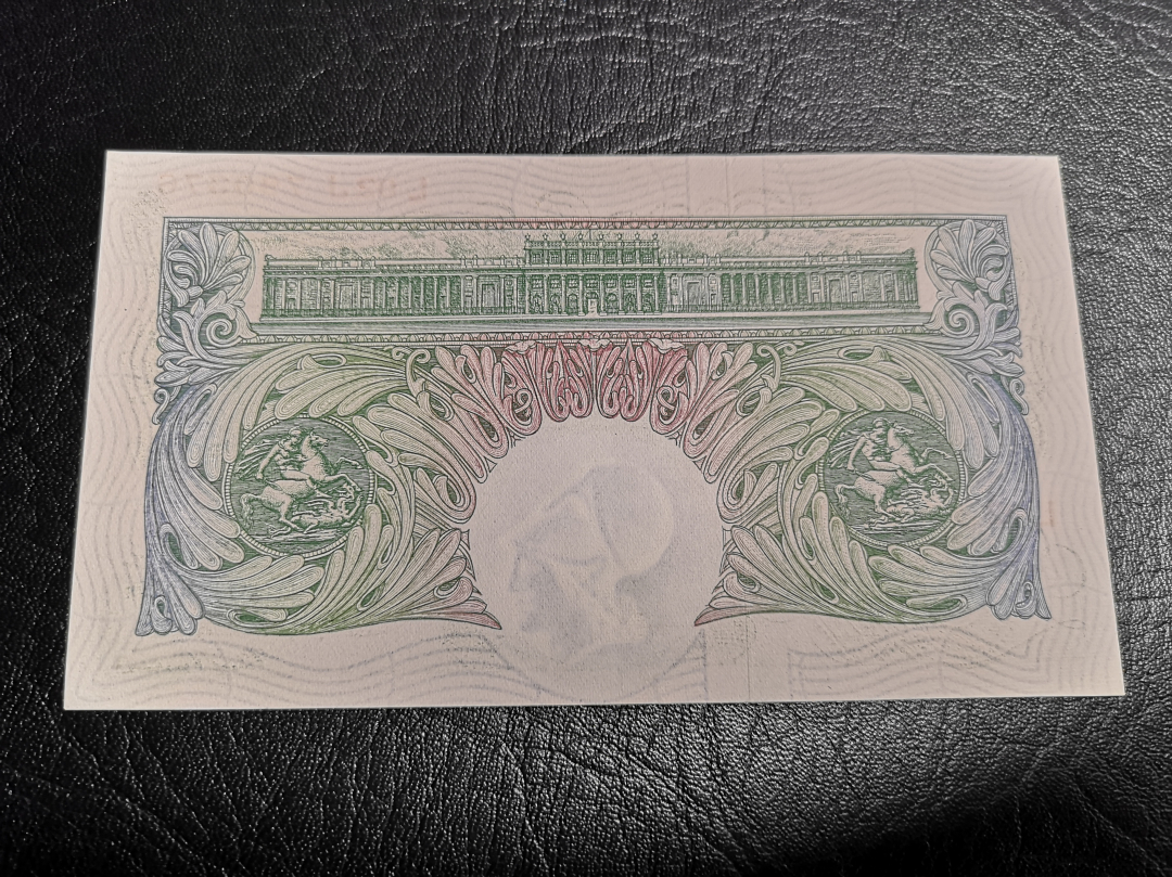 《外钞收藏家》第六十九期拍卖 英国A序列1镑 au品相，不仔细打光卡看不出问题，有软折