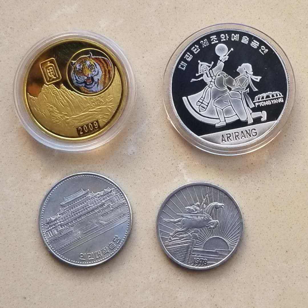 【币观天下】第八十二期钱币拍卖 朝鲜币章4枚:精制阿里郎铝制纪念币，虎年镀金铜章，50分流通币两枚。