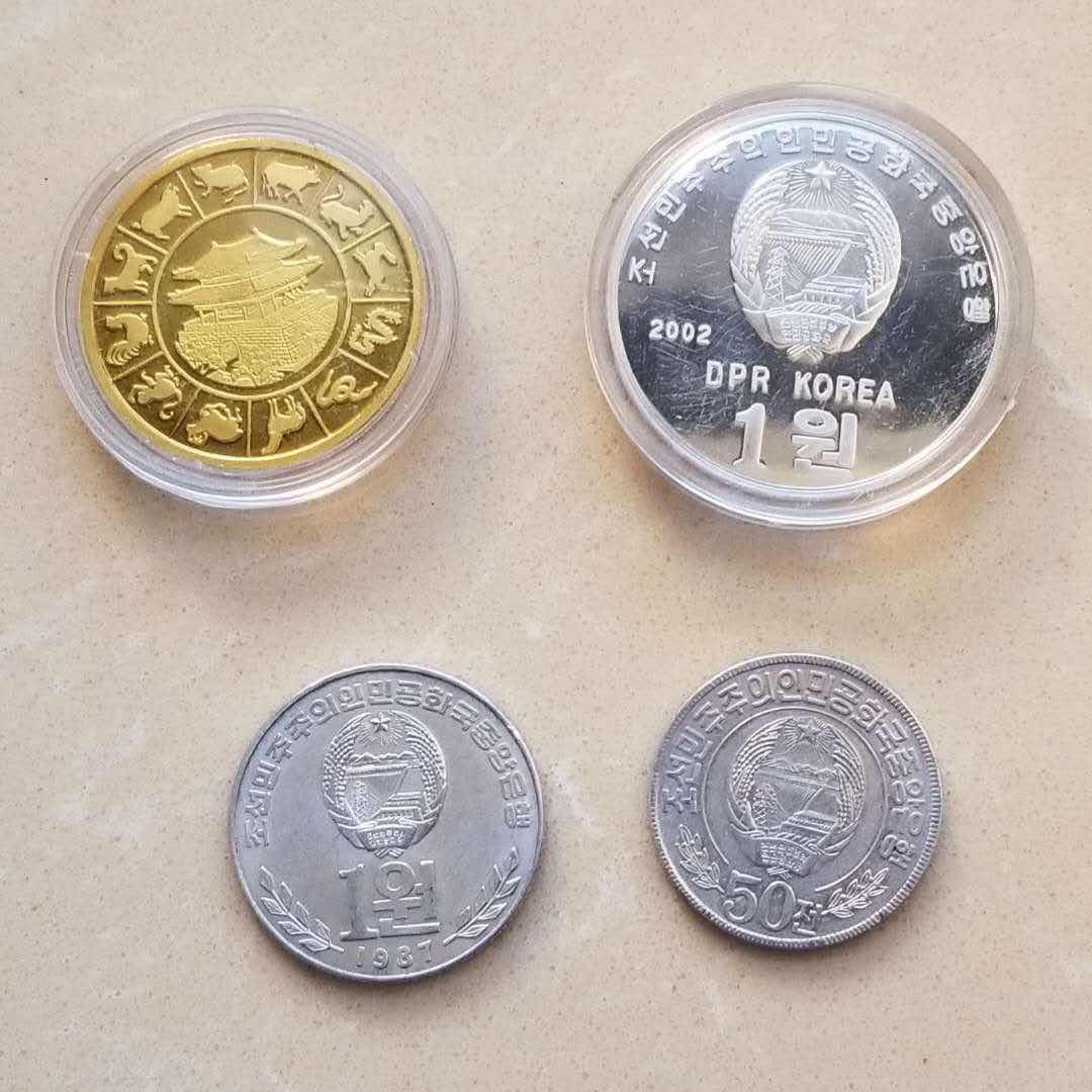 【币观天下】第八十二期钱币拍卖 朝鲜币章4枚:精制阿里郎铝制纪念币，虎年镀金铜章，50分流通币两枚。