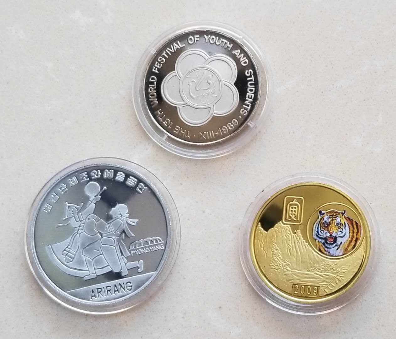 【币观天下】⭐️广州CICE展销会专场⭐️第八十五期钱币拍卖 朝鲜币章一组三枚:国际青年节5元精制镍币+阿里郎铝币+虎年镀金纪念章