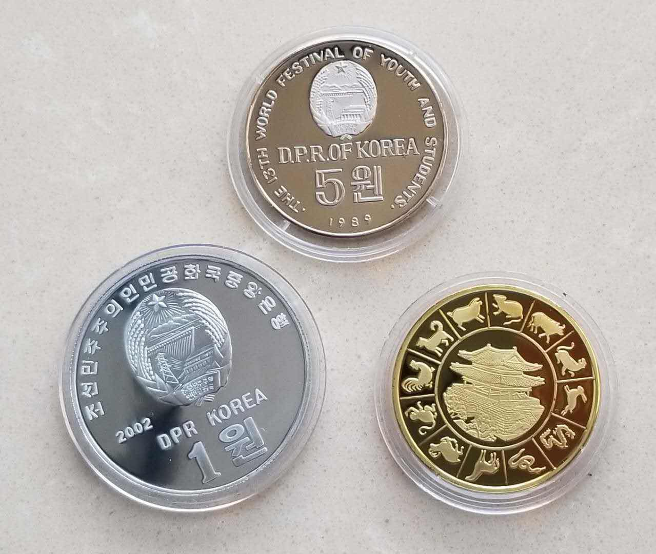 【币观天下】⭐️广州CICE展销会专场⭐️第八十五期钱币拍卖 朝鲜币章一组三枚:国际青年节5元精制镍币+阿里郎铝币+虎年镀金纪念章