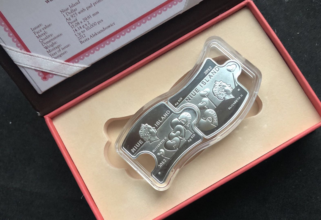 【币观天下】第八十六期钱币拍卖 纽埃2012年2(1+1)新西兰元，情人节“你和我”爱情相依，镶嵌施华洛世奇绿水晶、拼图扣合，彩色精制银币2枚套装