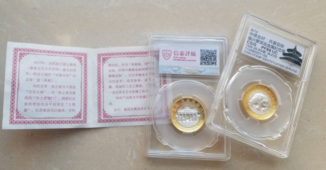 【币观天下】第101期钱币拍卖 信泰2017年“中德友好”纪念章一套（两枚) 庆祝中国与德国（德意志民主共和国）建交45周年，特设计制作“中德友好”纪念章一套（两枚）。  