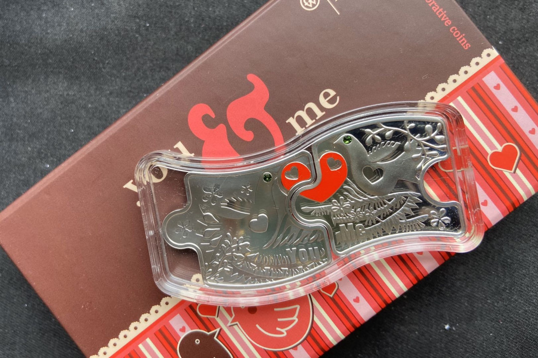 【币观天下】107期钱币拍卖 【纽埃】纽埃2012年2(1+1)新西兰元，情人节“你和我”爱情相依，镶嵌施华洛世奇绿水晶、拼图扣合，彩色精制银币2枚套