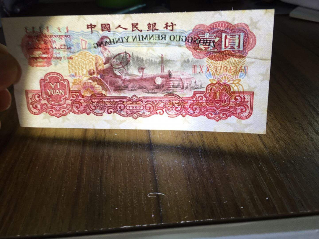 三版一元大错币，大皱折，几乎从头折到尾，下面还有一道小皱折