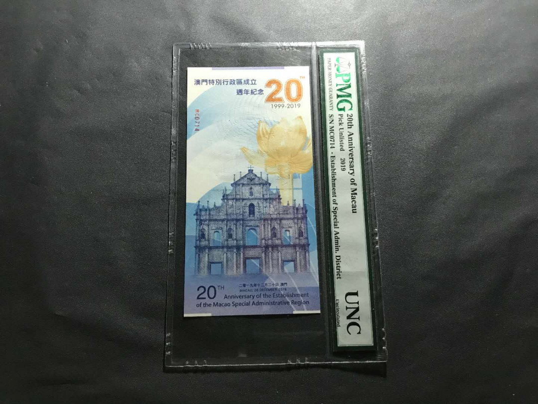【鲸贝乐淘】千字文·第“杜稿钟隶，漆书壁经”号拍卖 44澳门特区成立20周年纪念券一张，发行总量只有5000张PMG封评只有1000张正面大三八牌坊地标建筑，反面九龙壁的经典龙。凹凸印多色纤维彩丝荧光靓丽已经PMG装盒UNC=66E