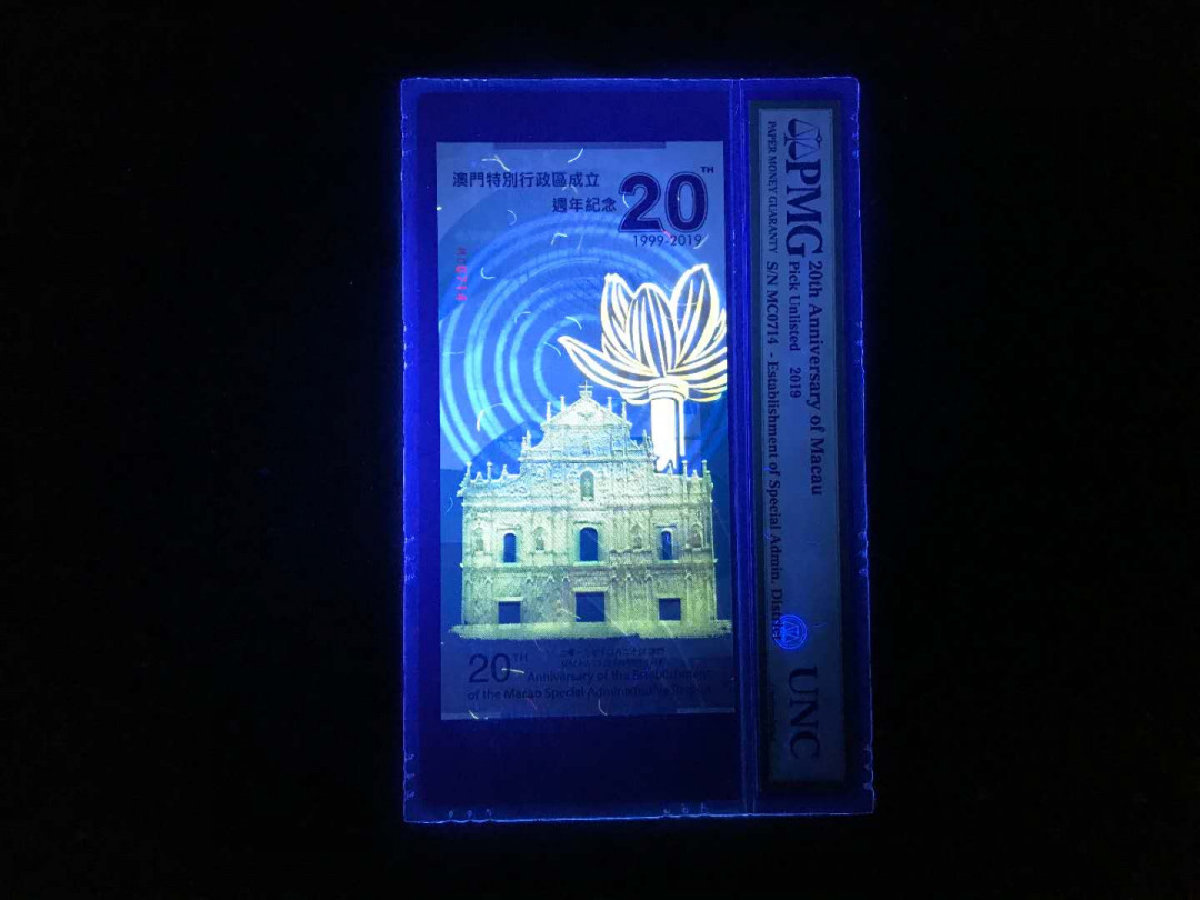 【鲸贝乐淘】千字文·第“杜稿钟隶，漆书壁经”号拍卖 44澳门特区成立20周年纪念券一张，发行总量只有5000张PMG封评只有1000张正面大三八牌坊地标建筑，反面九龙壁的经典龙。凹凸印多色纤维彩丝荧光靓丽已经PMG装盒UNC=66E