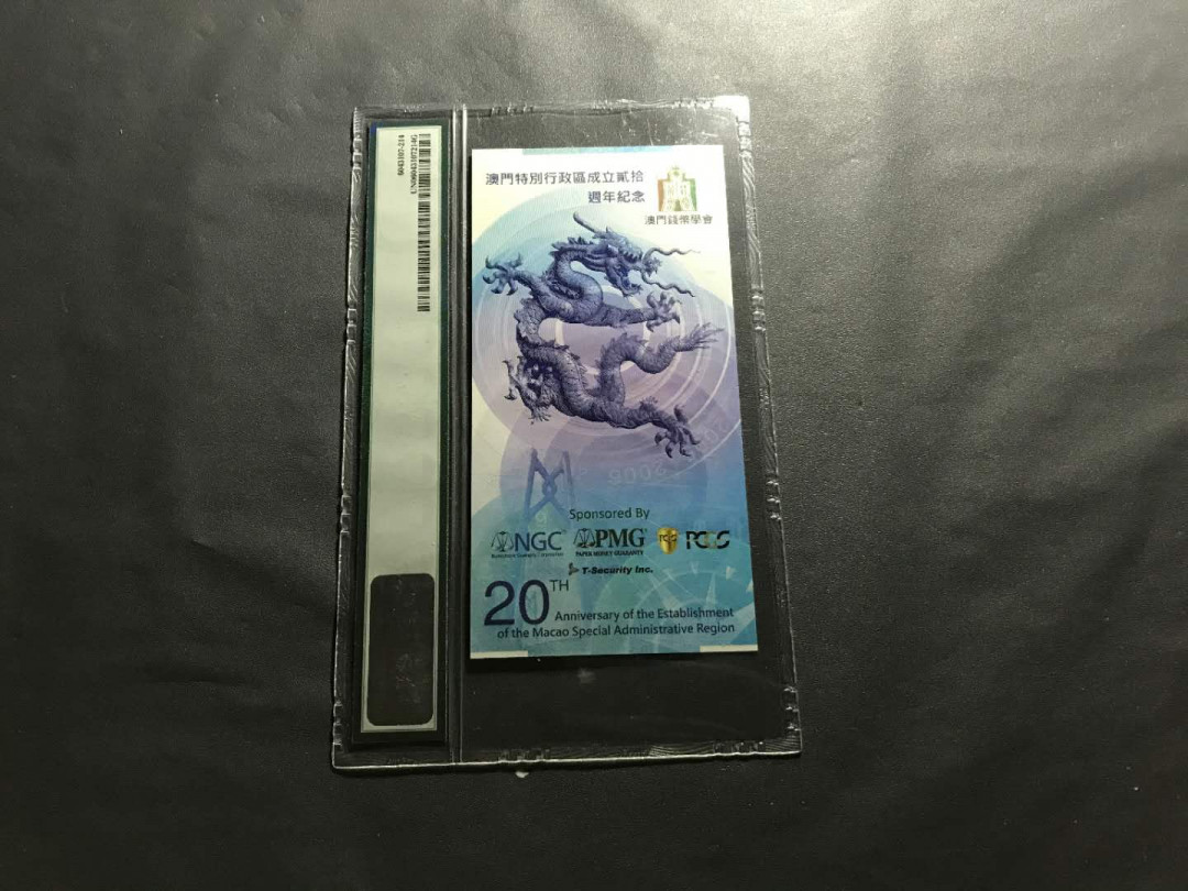 【鲸贝乐淘】千字文·第“杜稿钟隶，漆书壁经”号拍卖 44澳门特区成立20周年纪念券一张，发行总量只有5000张PMG封评只有1000张正面大三八牌坊地标建筑，反面九龙壁的经典龙。凹凸印多色纤维彩丝荧光靓丽已经PMG装盒UNC=66E