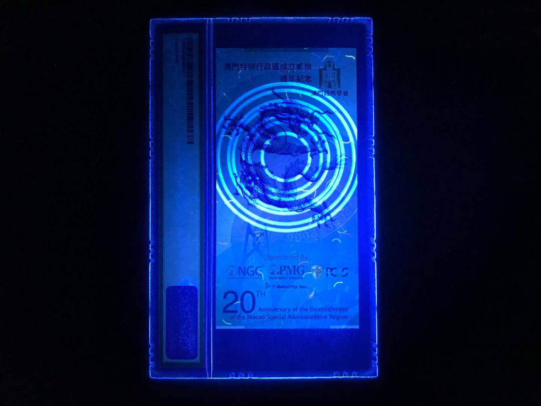 【鲸贝乐淘】千字文·第“杜稿钟隶，漆书壁经”号拍卖 44澳门特区成立20周年纪念券一张，发行总量只有5000张PMG封评只有1000张正面大三八牌坊地标建筑，反面九龙壁的经典龙。凹凸印多色纤维彩丝荧光靓丽已经PMG装盒UNC=66E