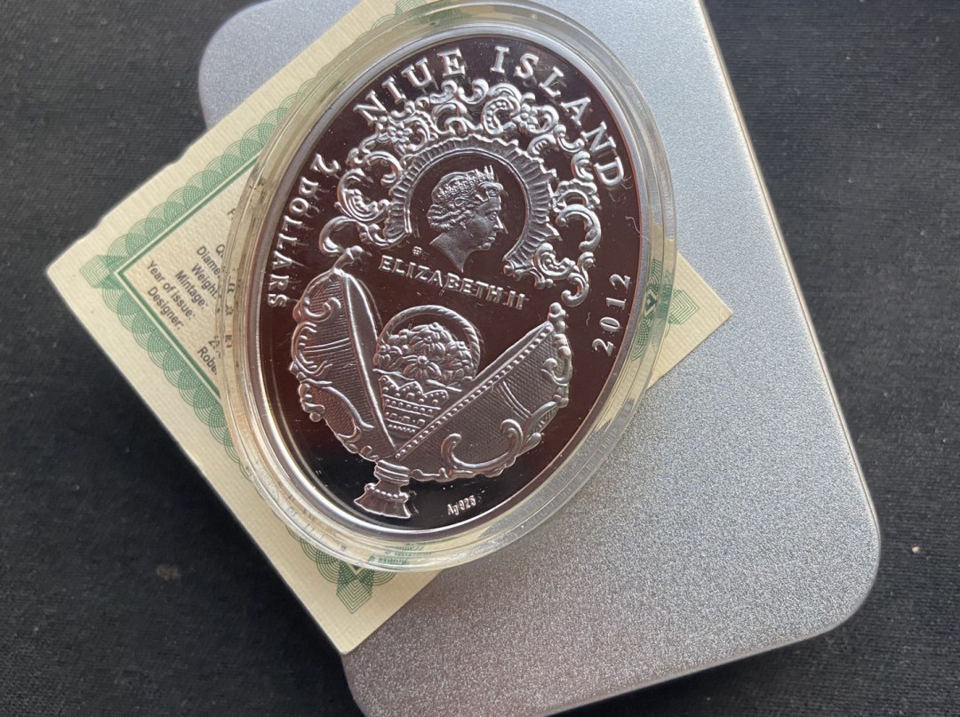 【币观天下】第130场钱币拍卖～ 【纽埃】纽埃2012年2元，56.56克 皇家费伯奇彩蛋系列---“香味甜月桂”，镶嵌紫色施华洛世奇宝石(4颗) 异形(椭圆形) 精制纪念银币