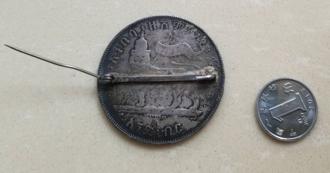 【币观天下】第134场拍卖【元旦场】 埃塞俄比亚帝国1比尔老银币胸针挂件  重30克品如图，胸针式饰品，非洲的古旧钱币加工制品少见