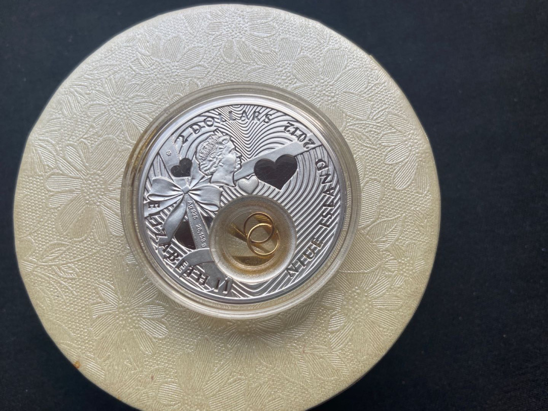 【币观天下】第138场钱币拍卖 纽埃2012年2元，28.28克，情人节爱情系列---“浪漫婚礼”，双面通透中空镶嵌银镀24K金可旋转“连心对戒”数码亮光彩色精致艺术银币