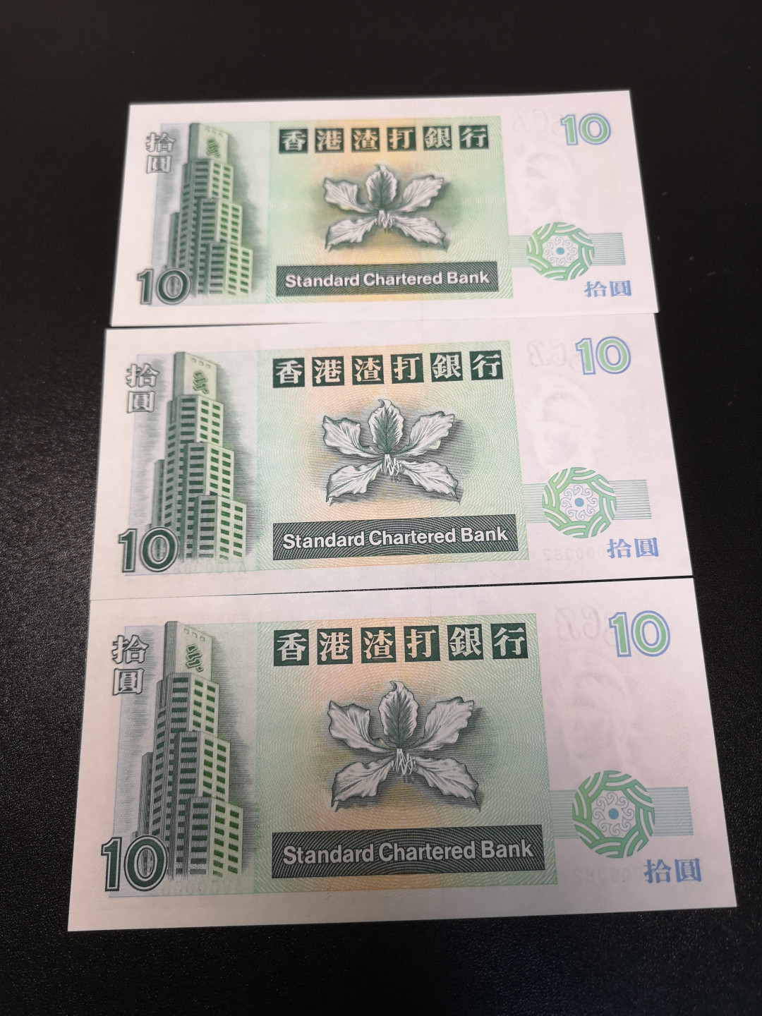 《外钞收藏家》第一百零八期拍卖 1993年香港渣打银行10港币 82号三张同号 全新UNC