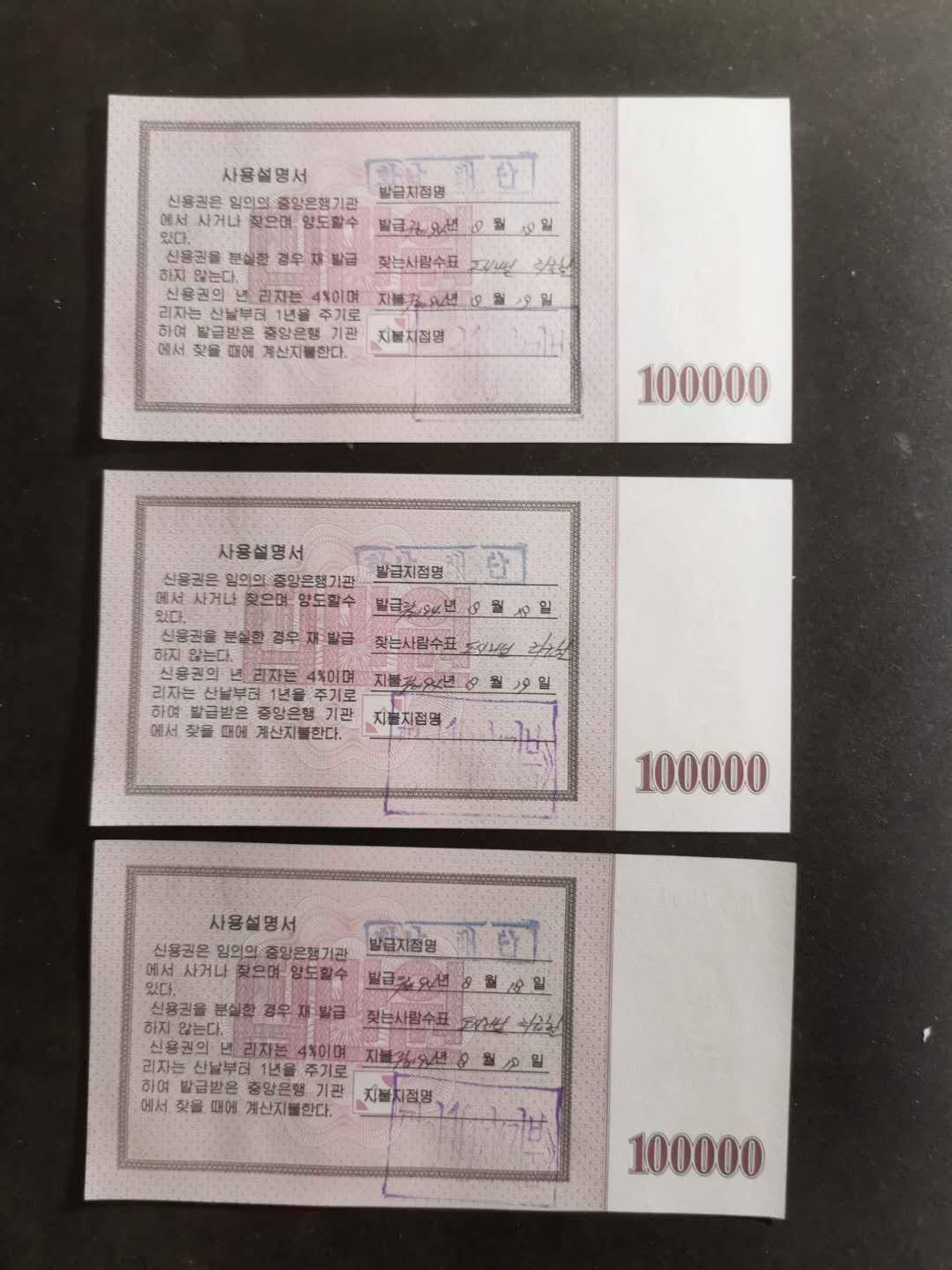 【鲸贝乐淘】千字文·第“孟轲敦素，史鱼秉直”号拍卖 【朝鲜🇰🇵 】2003年国库券10万元，三连号，UNC品相，背戳使用过，少见