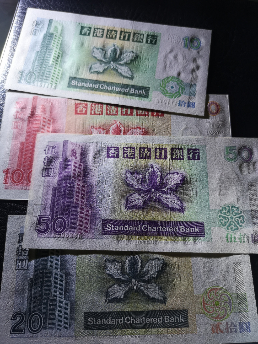 《外钞收藏家》第一百二十期拍卖 1993年香港渣打银行 A冠小套四张 100是豹子号 50和100有轻微潮癍 如图 其他 全新UNC